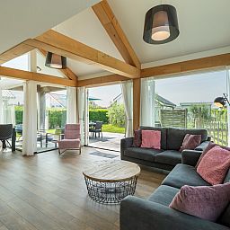 Lichte woonkamer in Vakantiehuis Zonnedorp 27 Beach Villa Renesse met uitzicht op de tuin.