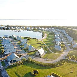 Luchtfoto van Vakantiehuis Oesterdam Resort in Tholen, Zeeland, met prachtig uitzicht op het meer en groene omgeving.