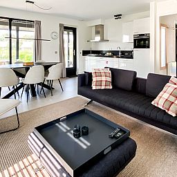 Stijlvolle woonkamer in Vakantiehuis Oesterdam Resort in Tholen, Zeeland met open keuken.