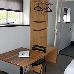 Cozy indoor area of Holiday cottage in Koudekerke, Walcheren, Zeeland with wooden table and comfortable bedroom.