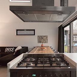 Gemuetlicher Innenbereich des Ferienhauses in Koudekerke, Zeeland, mit Kueche und Sitzecke.