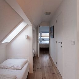 Schlafzimmer mit Holzboden im Ferienhaus in Koudekerke, Zeeland fuer eine gemuetliche Uebernachtung.