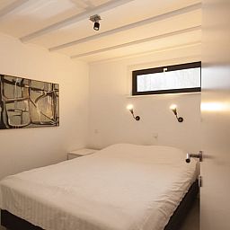 Geraeumiges Schlafzimmer im Ferienhaus in Koudekerke, Walcheren mit modernen Kunstwerken.