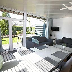 Lichte woonkamer in VZ986 Vakantiebungalow in Oostkapelle met uitzicht op de tuin in Walcheren, Zeeland.