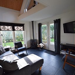 Modernes Wohnzimmer des Ferienhauses VZ1174 in Oostkapelle mit Blick auf den Garten.