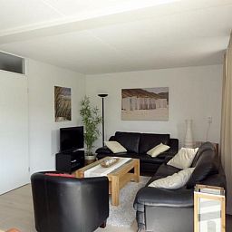 Gemuetliches Wohnzimmer im Ferienhaus VZ2416, Oostkapelle, Walcheren, mit bequemen Sitzgelegenheiten und Dekoration.