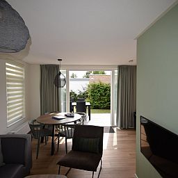 Gemuetliches Wohnzimmer des Ferienhauses VZ1078 in Oostkapelle mit Essecke und Gartenblick.