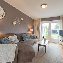 Gemuetliches Wohnzimmer des Ferienhauses VZ1162 in Oostkapelle, Walcheren mit bequemem Sofa.