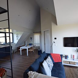 Gezellige woonkamer van VZ1092 Appartement in Oostkapelle, Walcheren, Zeeland met comfortabele bank en TV.