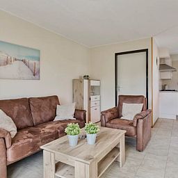 Gezellige woonkamer in Vakantiewoning Oostkapelle, Walcheren, met comfortabele zitruimte en moderne keuken, op slechts 800 m van het strand.