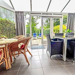 Cozy conservatory in Apartment Boszicht 1, Oostkapelle, Walcheren, overlooking the garden.