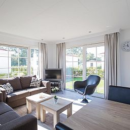 Helles Wohnzimmer des Chalets VZ983 in Oostkapelle, Walcheren, mit Blick auf den Garten.