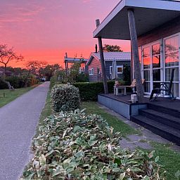 Gezellige slaapkamer in ZE1593 vakantiehuis Oostkapelle, Walcheren, met tweepersoonsbed en bloemen.