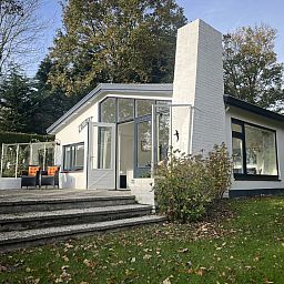Geniet van de zonnige veranda van vakantiehuis ZE1678 in Oostkapelle, Walcheren, Zeeland, met comfortabele zitplaatsen en groene omgeving.