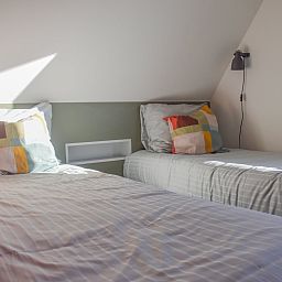 Comfortable bedroom in ZE1315 vacation home, Westkapelle, Walcheren, Zeeland with double bed and colorful pillows.