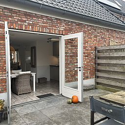 Sfeervolle slaapkamer in vakantiehuis ZE1677 in Domburg, Walcheren, Zeeland, met dakramen en uitzicht op de charmante daken van de omgeving.