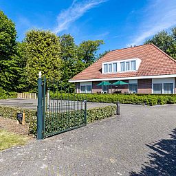 Ruim terras met groene parasols bij ZE014 vakantiehuis, Domburg, Walcheren, omgeven door natuur voor een ontspannen sfeer.