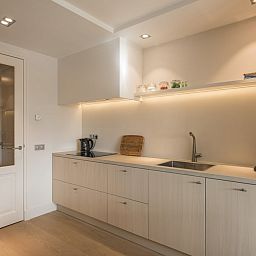 Moderne keuken in Champagne Wellness 6 vakantiehuis in Domburg, Walcheren met strakke afwerking.