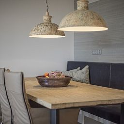 Gezellige eethoek in Champagne Wellness 6 appartement in Domburg met houten tafel en sfeervolle lampen.
