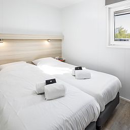 Slaapkamer in L4A Comfort vakantiehuis Domburg, Walcheren, Zeeland met comfortabele bedden en rustgevend uitzicht.