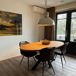 Eetgedeelte in Bordeaux 4 appartement in Domburg, Walcheren, Zeeland met houten tafel en uitzicht.