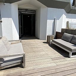 Zonnige buitenruimte van VZ675 Strandwoning Vlissingen 4p in Vlissingen, Walcheren, Zeeland met comfortabele banken.