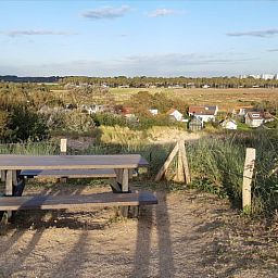 Uitzicht op de omgeving van Vakantiehuisje in Vlissingen, Walcheren, met weids landschap en picknicktafel.
