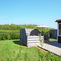 Terrasse des Ferienhauses in Zoutelande, umgeben von viel Gruen, ideal fuer Entspannung in Walcheren, Zeeland.