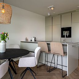 Dining table and kitchen in Lamsoor 47 | Veerse Wende, vacation accommodation in Arnemuiden, Walcheren, Zeeland.