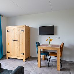 Gemuetlicher Innenbereich des Ferienhauses ZE583 in Vrouwenpolder, Walcheren mit Esstisch und Fernseher in Zeeland.