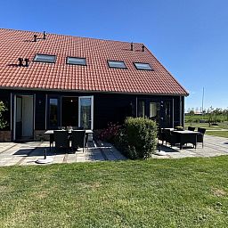 Die sonnige Terrasse von VZ587 Ferienhaus Vrouwenpolder, Walcheren, ist ideal fuer Mahlzeiten im Freien.