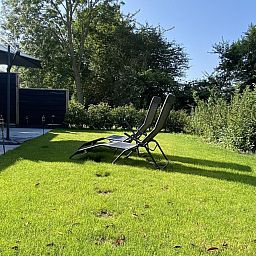 Relax on the sun loungers in the garden of VZ1064 Luxury vacation apartment in Veere, Walcheren, Zeeland.