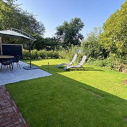 Spacious garden with shaded areas at VZ1064 Luxury vacation apartment in Veere, Walcheren, Zeeland.