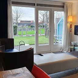 Innenbereich des Ferienhauses THE SUN IN STEE ON ZEE in Serooskerke, Walcheren, mit Gartenblick und moderner Einrichtung.