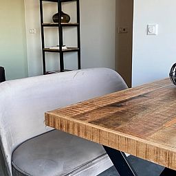 Gezellige eetruimte in Huisje in Middelburg, vakantiehuis in Middelburg, Walcheren, Zeeland met houten tafel en comfortabele zitplek.