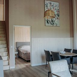 Moderne woonkamer van Vakantiehuis in Ritthem, Walcheren, met eetgedeelte en trap.