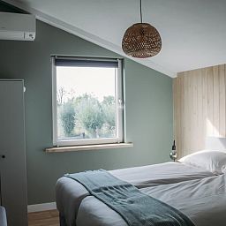 Gezellige slaapkamer met uitzicht op de natuur in Vakantiehuis in Ritthem, Zeeland.