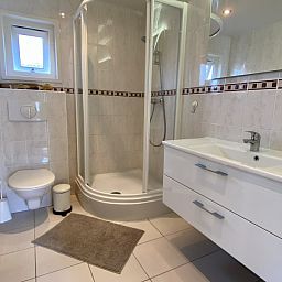 Moderne badkamer in Casa Mari chalet, Breskens, Zeeuws-Vlaanderen, met ruime douche en strakke inrichting voor ultiem comfort.