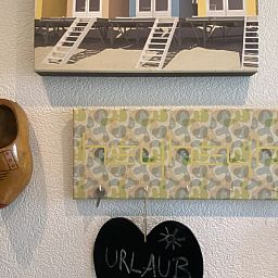 Authentieke decoratie in Casa Mari, chalet in Breskens, Zeeuws-Vlaanderen, met klompen en strandkunst voor een lokale sfeer.