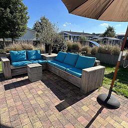 Sonnige Terrasse mit blauen Kissen im Ferienhaus VZ808 in Breskens, Zeeuws-Vlaanderen.