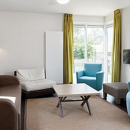 Cozy living room of Lodge 6C, a vacation home in Breskens, Zeeuws-Vlaanderen, Zeeland with modern furniture and lots of natural light.