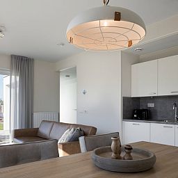 Moderne binnenruimte van L4A Comfort vakantiehuis in Nieuwvliet-Bad, Zeeland met open keuken en uitzicht op het terras.