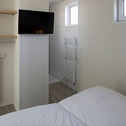 Moderne slaapkamer in L4A Comfort vakantiehuis, Nieuwvliet-Bad, Zeeuws-Vlaanderen, met comfortabele faciliteiten en serene sfeer.