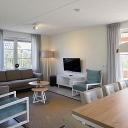 Gemuetliches Wohnzimmer im V8 Luxus-Ferienhaus in Nieuwvliet-Bad, Zeeland, mit komfortabler Sitzecke.