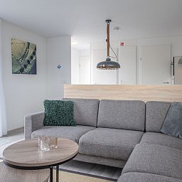 Stijlvolle woonkamer in L6 Comfort vakantiehuis in Nieuwvliet-Bad, Zeeuws-Vlaanderen, met moderne inrichting en comfortabele zithoek.