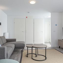 Modernes Wohnzimmer im Ferienhaus L4 Comfort in Nieuwvliet-Bad, Zeeuws-Vlaanderen, Zeeland mit gemuetlicher Sitzecke und TV.