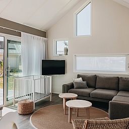 Gemuetliches Wohnzimmer in Babylodge 4+1, einem Ferienhaus in Nieuwvliet-Bad, Zeeuws-Vlaanderen mit moderner Einrichtung und viel Tageslicht.