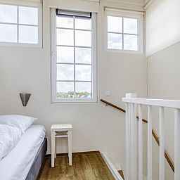 Sfeervolle slaapkamer in Villa 9A, vakantiehuis in Cadzand-bad, Zeeuws-Vlaanderen, Zeeland, met twee comfortabele bedden en natuurlijk licht.