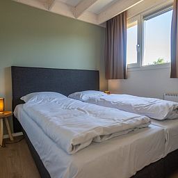 Gezellige slaapkamer in Vrijstaande woning in Cadzand, Zeeuws-Vlaanderen, Zeeland met comfortabel tweepersoonsbed en veel natuurlijk licht.