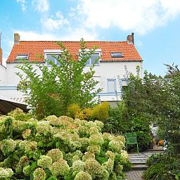 Exterior of VZ052 Apartment Sluis in Sluis, Zeeuws-Vlaanderen, surrounded by lush garden.